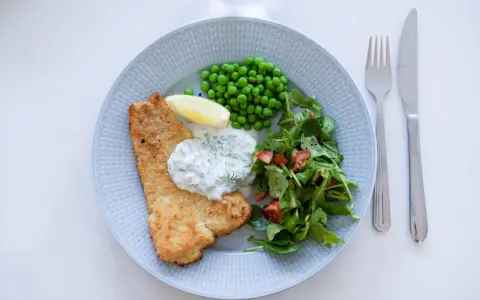 Panerad fisk med ärtor, sallad och en krämig skolans dillsås. En klassisk svensk rätt som smakar sommar.