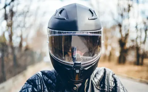 Casco moto nero con visiera trasparente, pronto per la strada. La scadenza del casco moto è un promemoria per la sicurezza.