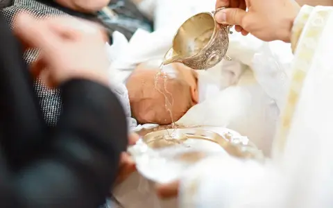 Chrzest dziecka: woda święcona na główkę. Po obrzędzie zakładana jest szatka do chrztu.