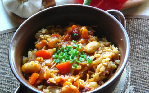 Pyszna kasza bulgur gotowanie z warzywami i fasolą, posypana szczypiorkiem. Aromatyczne danie, które zachwyca smakiem.