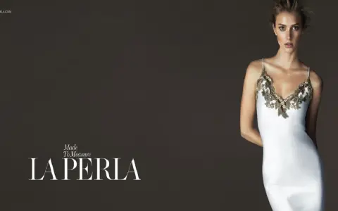 Model in a white slip dress with gold lace trim, with "LA PERLA" logo.