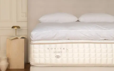 Un matelas Sofitel My Bed, symbole d'un choix literie de luxe, avec des draps blancs et des oreillers moelleux.