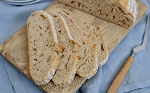 Aufgeschnittenes italienisches Brot mit Lievito Madre auf einem Holzbrett, bereit zum Genießen.
