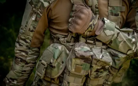 Żołnierz w mundurze moro, z rękawiczkami taktycznymi. Wytrzymałość materiału, czy to cordura 500 czy 1000, jest kluczowa w terenie.