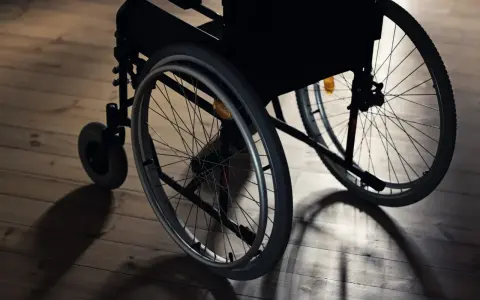 Wózek inwalidzki na drewnianej podłodze. Czy lekarz rodzinny może wystawić zlecenie na wózek inwalidzki?
