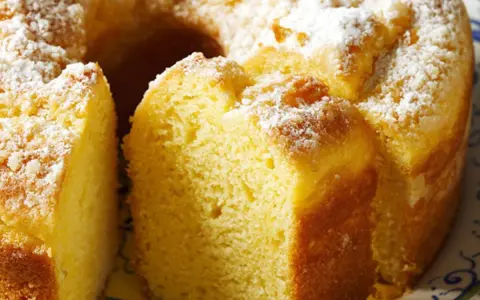 Un soffice ciambellone allo yogurt, cosparso di zucchero a velo, pronto per essere gustato.