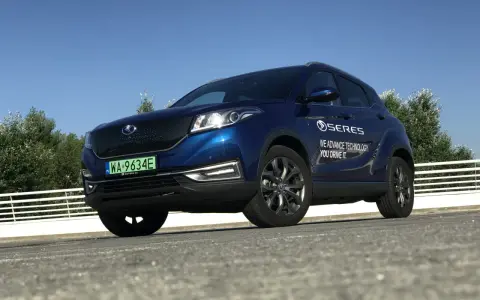 Niebieski SUV Seres 3 zaparkowany na zewnątrz, z widocznym logo i napisem.