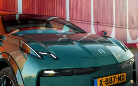 El elegante Zeekr X, un coche eléctrico verde oscuro, se exhibe con su distintivo logo y faros LED, listo para la aventura.