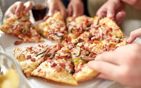 Hände greifen nach leckeren Stücken einer glutenfreien Pizza. Ein tolles glutenfreies Pizza Rezept für alle!