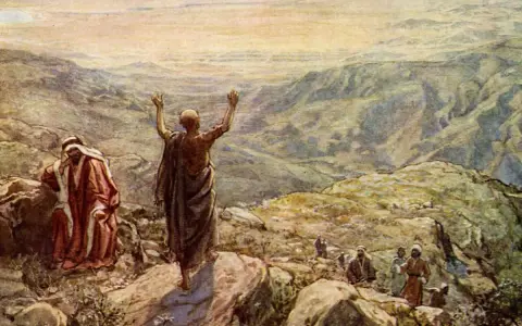 Balaam in the Bible, with arms raised, blesses Israel from a mountaintop. Another man in red looks on.