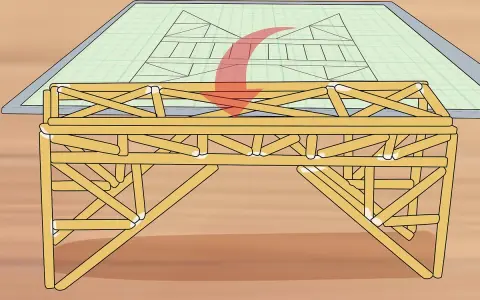 Un modelo de puentes de madera se construye sobre un plano de ingeniería.