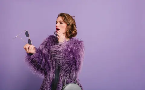 Chica con abrigo morado y maquillaje vibrante, lista para un evento.