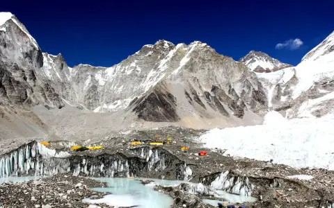 Niezwykły widok z bazy pod Mount Everest. Kolorowe namioty obozowe na tle lodowca i surowych, ośnieżonych szczytów. To początek ekscytującego **trekking pod Mount Everest**.