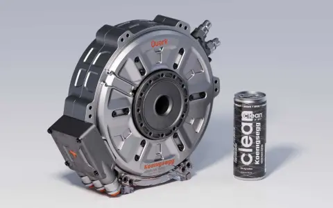 Silnik elektryczny Koenigsegg Quark obok puszki napoju energetycznego.