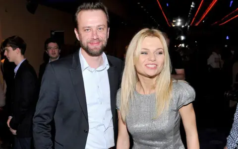 Julia Balsewicz w srebrnej sukience i mężczyzna w czarnym garniturze uśmiechają się do obiektywu.