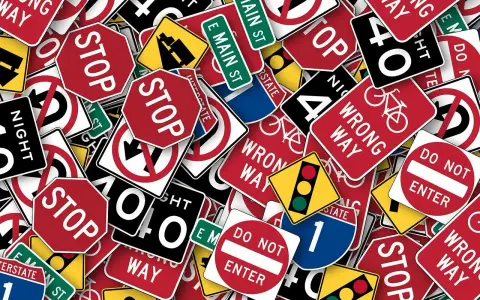 Un groviglio di segnali stradali, tra cui "STOP", "DO NOT ENTER" e "WRONG WAY", che ricordano l'art. 45 del Codice della Strada.