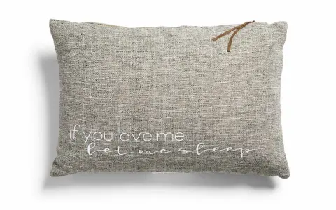 Cojines con frases: uno gris con "if you love me let me sleep" bordado en blanco y un detalle de cuero.