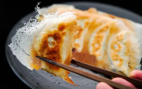 Chrupiące gyoza z delikatną, koronkową skórką, podniesione pałeczkami. Idealny przepis na gyoza!