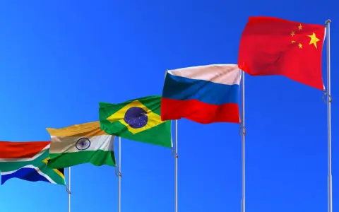 Fünf Flaggen (Südafrika, Indien, Brasilien, Russland, China) wehen im Wind. Die BRICS-Bedeutung wird durch diese Länder repräsentiert, die eine wachsende globale Rolle spielen.