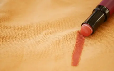 Rossetto su tessuto color pesca, un esempio pratico su come togliere il fondotinta dai vestiti.