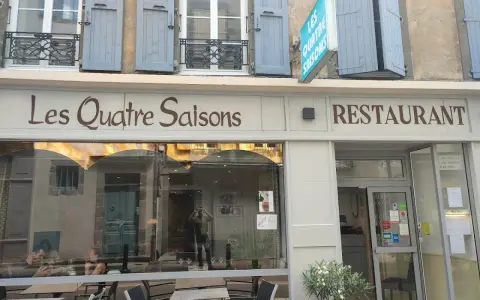 Le restaurant étoilé Les Quatre Saisons à Aurillac, une façade accueillante avec une enseigne lumineuse.