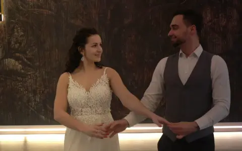 Para młoda w tańcu na tle abstrakcyjnej ściany.