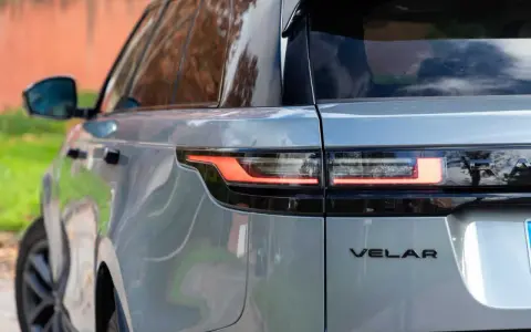 Detalle trasero de un Range Rover Velar plateado, mostrando sus luces LED y el emblema. Sus dimensiones son ideales para la ciudad y la aventura.