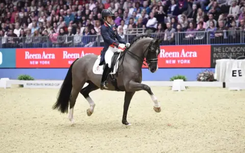 Un cavalier et son cheval Valegro, mort de beauté, exécutent une figure d'équitation devant une foule.