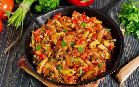 Poêlée de légumes colorée, une spécialité Côte d'Azur, avec courgettes, poivrons et tomates, garnie de persil frais.
