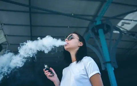 Joven exhala humo de un vaper, una práctica que demuestra que el vaper es malo para la salud.