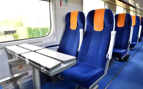 Wygodne siedzenia w pociągu PKP Intercity, gotowe na podróż do Warszawy.