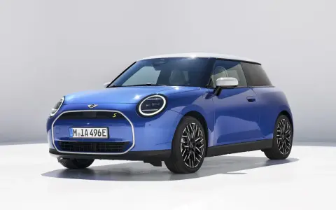 Niebieski Mini Cooper z białym dachem, jeden z tych małych aut, które pokochasz.