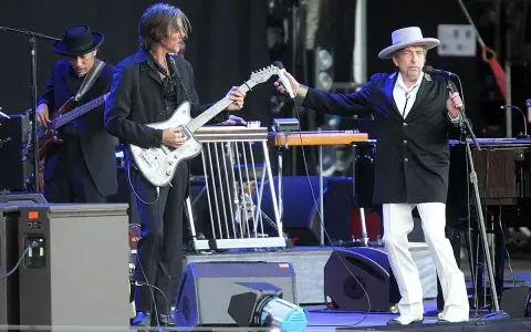 Bob Dylan på scen i Stockholm, med gitarrister och musiker.