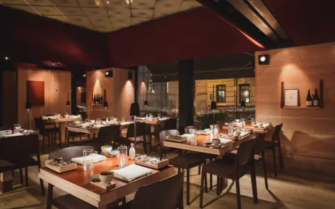 Elegant inredning på en michelin restaurang i Sverige. Vackert dukade bord med trädetaljer och dämpad belysning skapar en intim atmosfär.