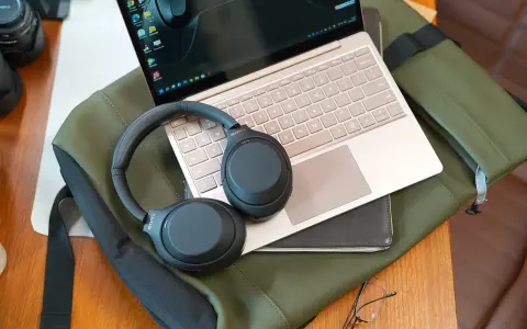 Słuchawki bezprzewodowe Sony leżą na laptopie, gotowe do połączenia. Dowiedz się, jak podłączyć słuchawki bezprzewodowe do laptopa, by cieszyć się dźwiękiem.