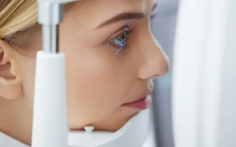 Esame oculistico: una donna con linee blu che indicano la pseudofachia dell'occhio.
