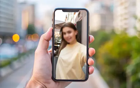 Chcesz wiedzieć, jak zamazać twarz na zdjęciu iPhone? Na ekranie telefonu widać rozmazaną twarz młodej kobiety.