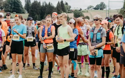 Läufer stehen bereit für den Lauf "3 Kings 3 Hills". Die Teilnehmenden tragen Startnummern und Laufbekleidung.