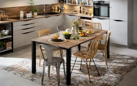 Tendance salle à manger avec chaises dépareillées : un mélange de style industriel et bohème autour d'une table en bois.