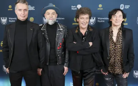 Czterech mężczyzn, w tym legendy polskie zespoły muzyczne lat 70-80, pozuje na ściance.