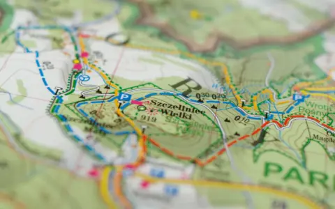 Mapa turystyczna z zaznaczonym szlakiem czerwonym, który oznacza najdłuższą trasę. Widoczne nazwy miejscowości i terenów.