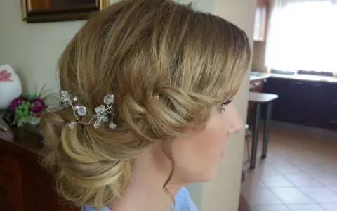 Eleganckie fryzury ślubne dla cienkich włosów: delikatny kok z kryształową ozdobą.