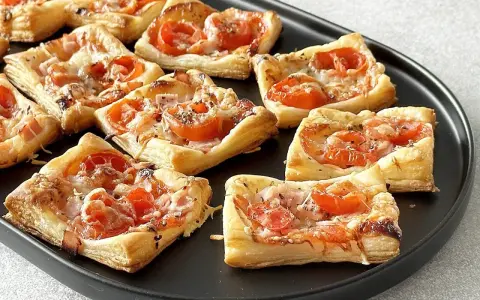 Pizzerinki z ciasta francuskiego z pomidorkami i serem, idealne na szybką przekąskę.