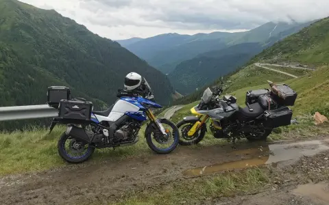 Dwa motocykle turystyczne z kuframi na górskiej drodze w Rumunii. Idealne na wyprawę motocyklem, co zabrać?