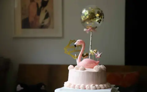 Różowy tort z flamingiem, złotymi serduszkami i koroną. Balon z konfetti dodaje magii. Idealny pomysł, jak udekorować tort na wyjątkową okazję.