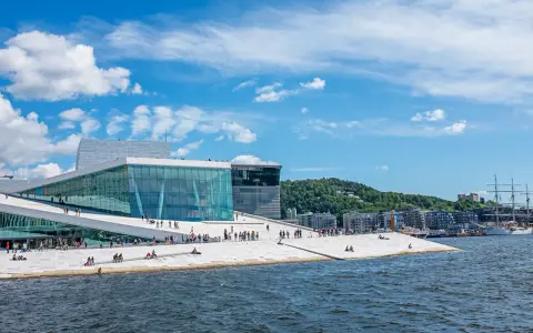 Ein sonniger Tag für Oslo Sightseeing am Opernhaus mit seiner einzigartigen Architektur und dem Wasser.