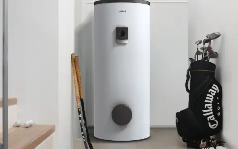 Ein moderner weißer warmwasserspeicher testet seine Leistung neben Golfschlägern und Bällen.