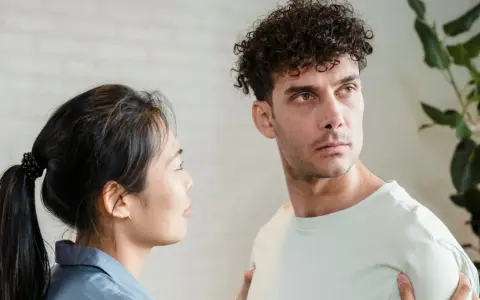Un homme au regard intense, peut-être un pervers narci, semble ignorer une femme qui le regarde avec inquiétude.