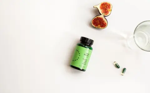 Grön burk med Meno Balance, fikon och kapslar. Stöd för dina upp- och nedgångar, utan kända biverkningar.