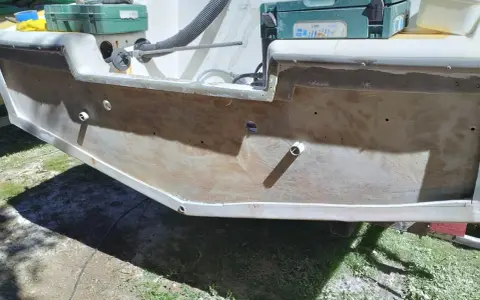 Préparation pour refaire le tableau arrière d'un bateau. Des outils et des matériaux sont visibles.